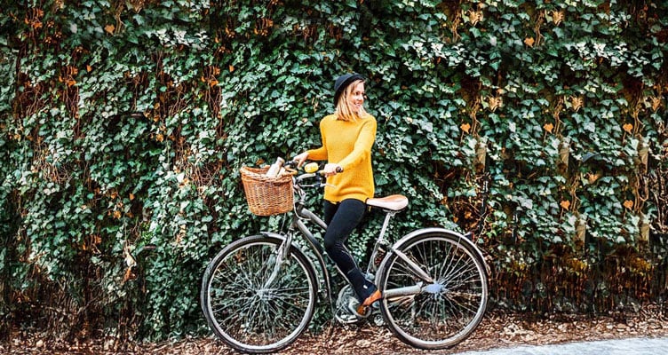 woman in a yellow jumper on a bicycle