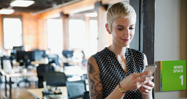 young woman with cropped hair looking at her phone