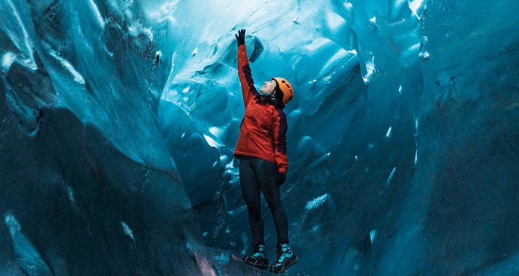 person in red jacket in ice cave
