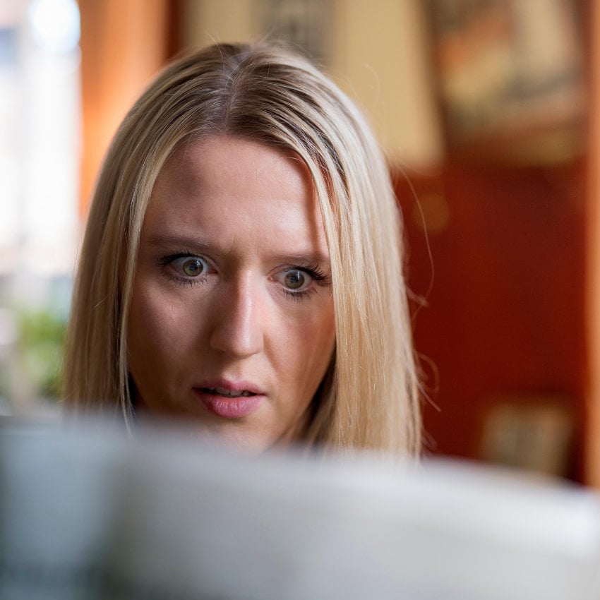 GR7Y42_850x850 Lesende Frau mit erschrecktem Gesichtsausdruck