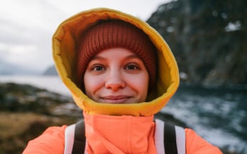Touristin mit Regenjacke nimmt ein Selfie von sich auf