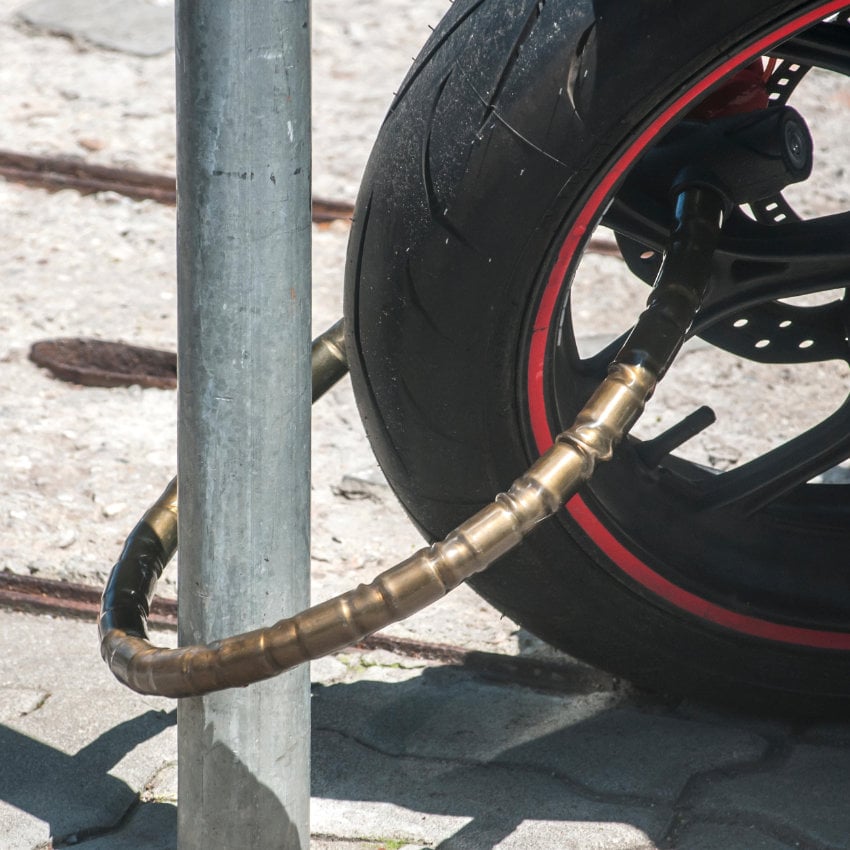PWDB2W Nahaufnahme eines an einen Laternenpfahl angeschlossenen Motorrad-Vorderrads