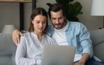 Mann und Frau blicken gemeinsam auf Laptop
