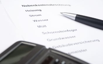 Nebenkostenabrechnung mit Kugelschreiber und Taschenrechner