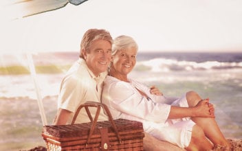 Älteres Paar beim Picknick am Strand