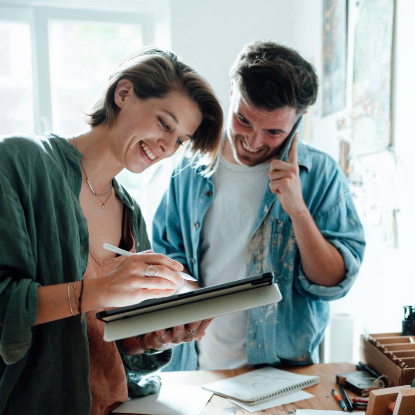 Telefonierender Mann mit Frau, die am Pad arbeitet Telefonierender Mann mit Frau, die am Pad arbeitet