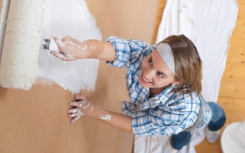 Frau beim Streichen einer Wand