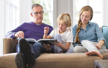 vater-liest-mit-kindern-auf-sofa