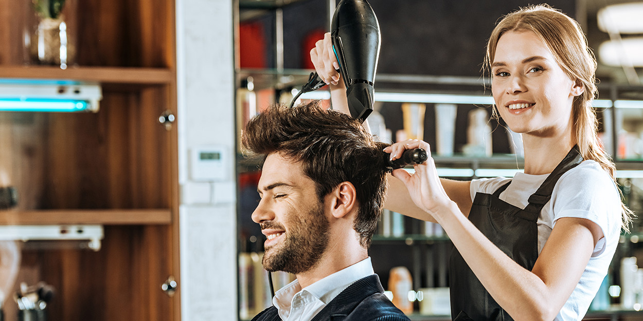 Friseurin föhnt Kunden die Haare