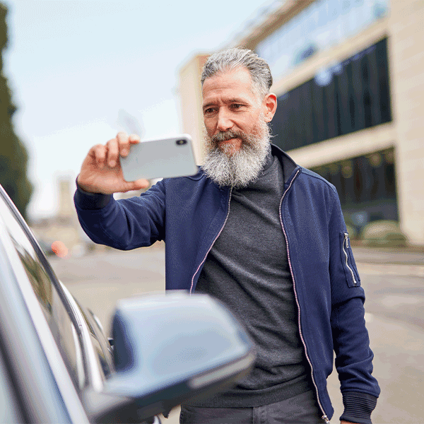 Man taking a picture of a car