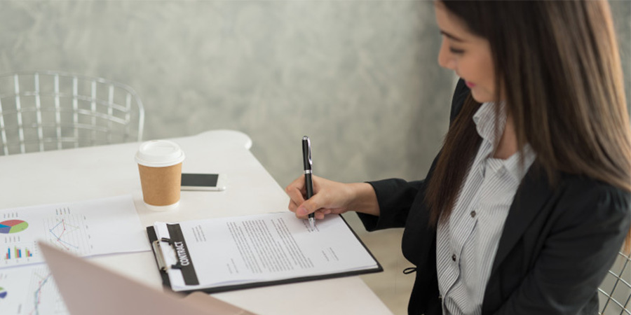 a woman signing a paper