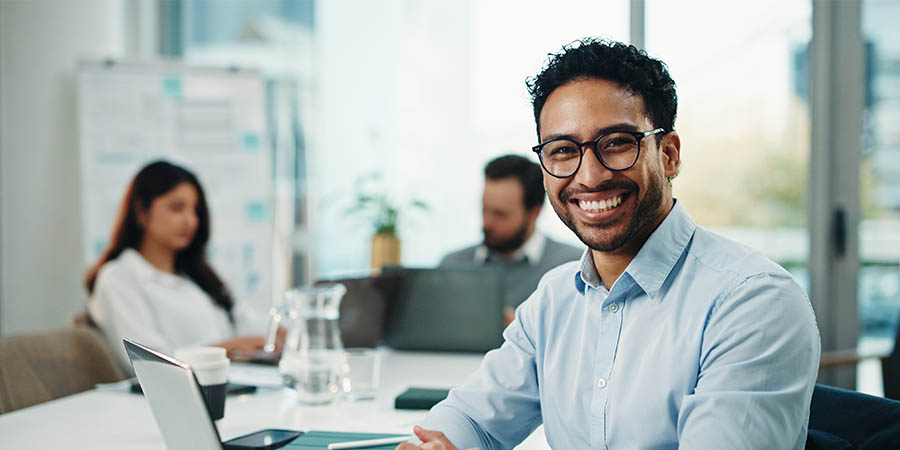 happy man sitting in the office with colleagues