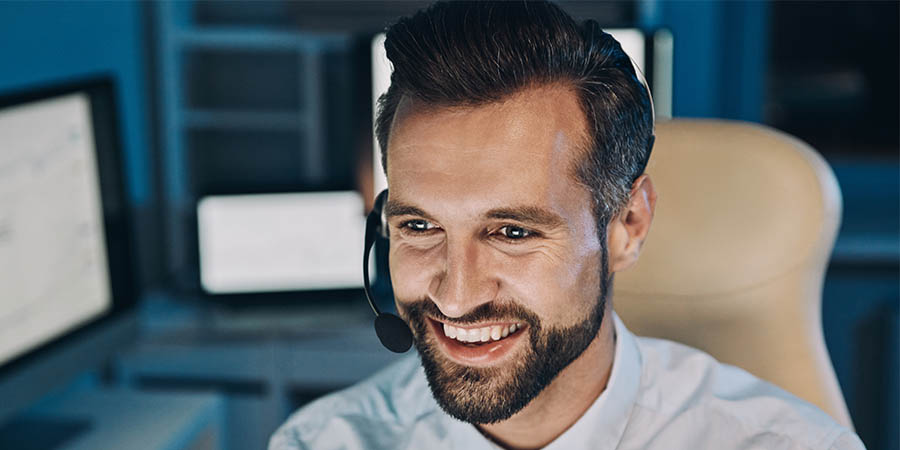man laughing and talking through a headset