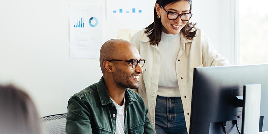 Web developers using a computer together in an office