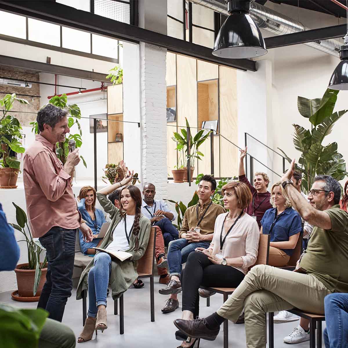 Business people with raised arms during seminar