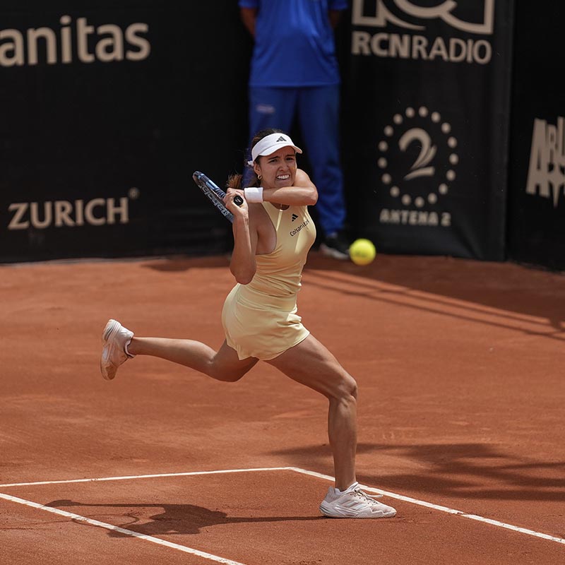 tennis player is hitting a backhand