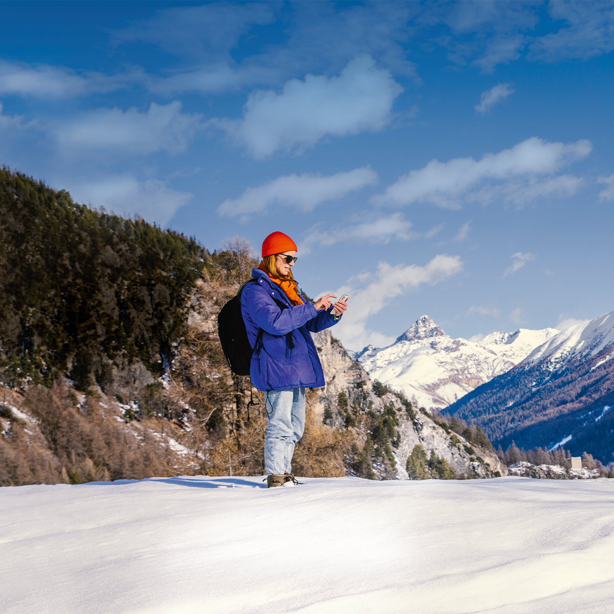 a woman standing in the snow in the mountains