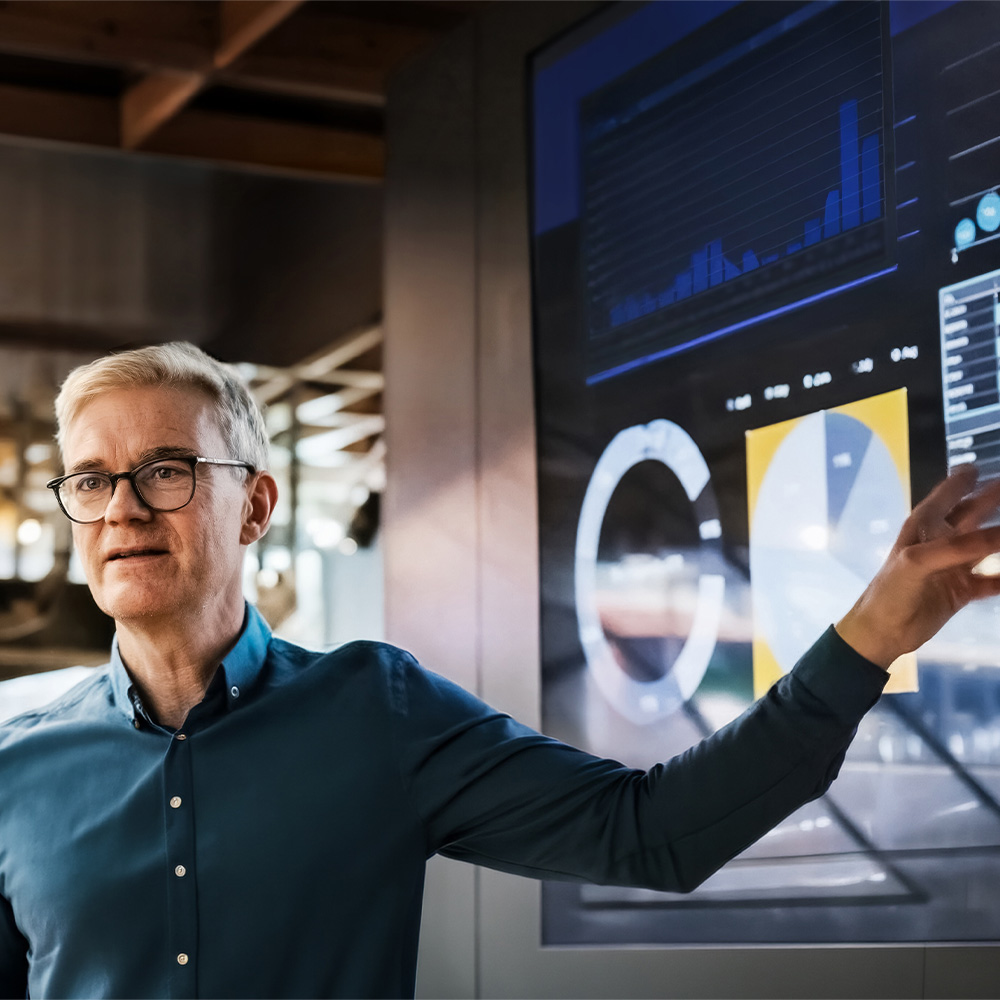 Man showing data and charts on a big screen