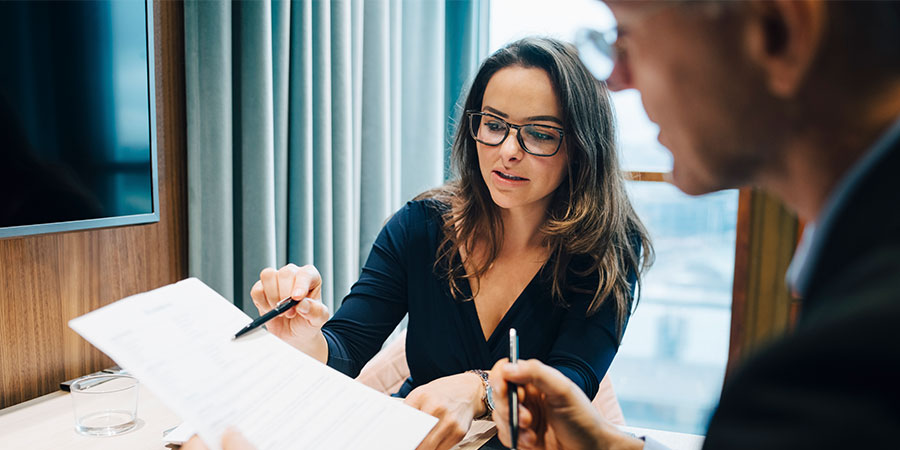 Male and female entrepreneur brainstorming over document during meeting in office