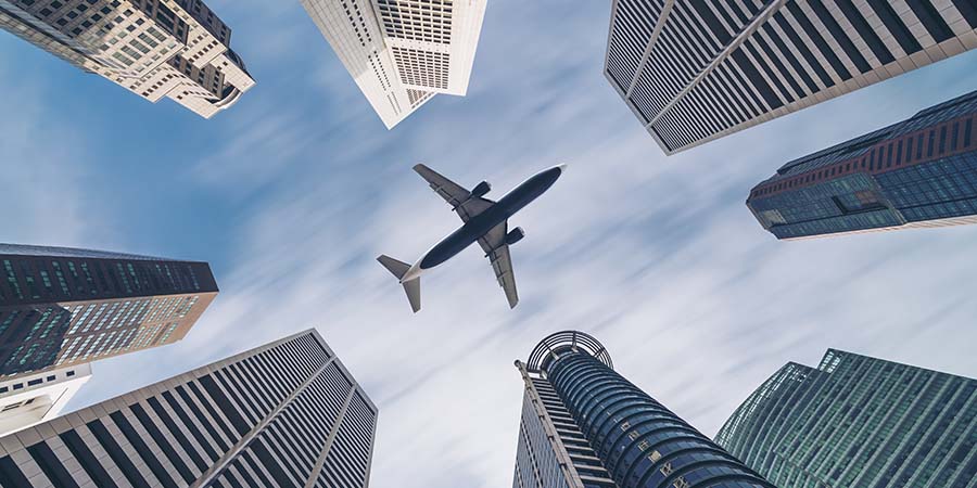 Jet plane aircraft traveling in the sky over city buildings