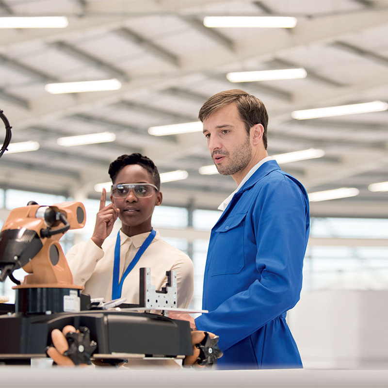 two people working with a robot