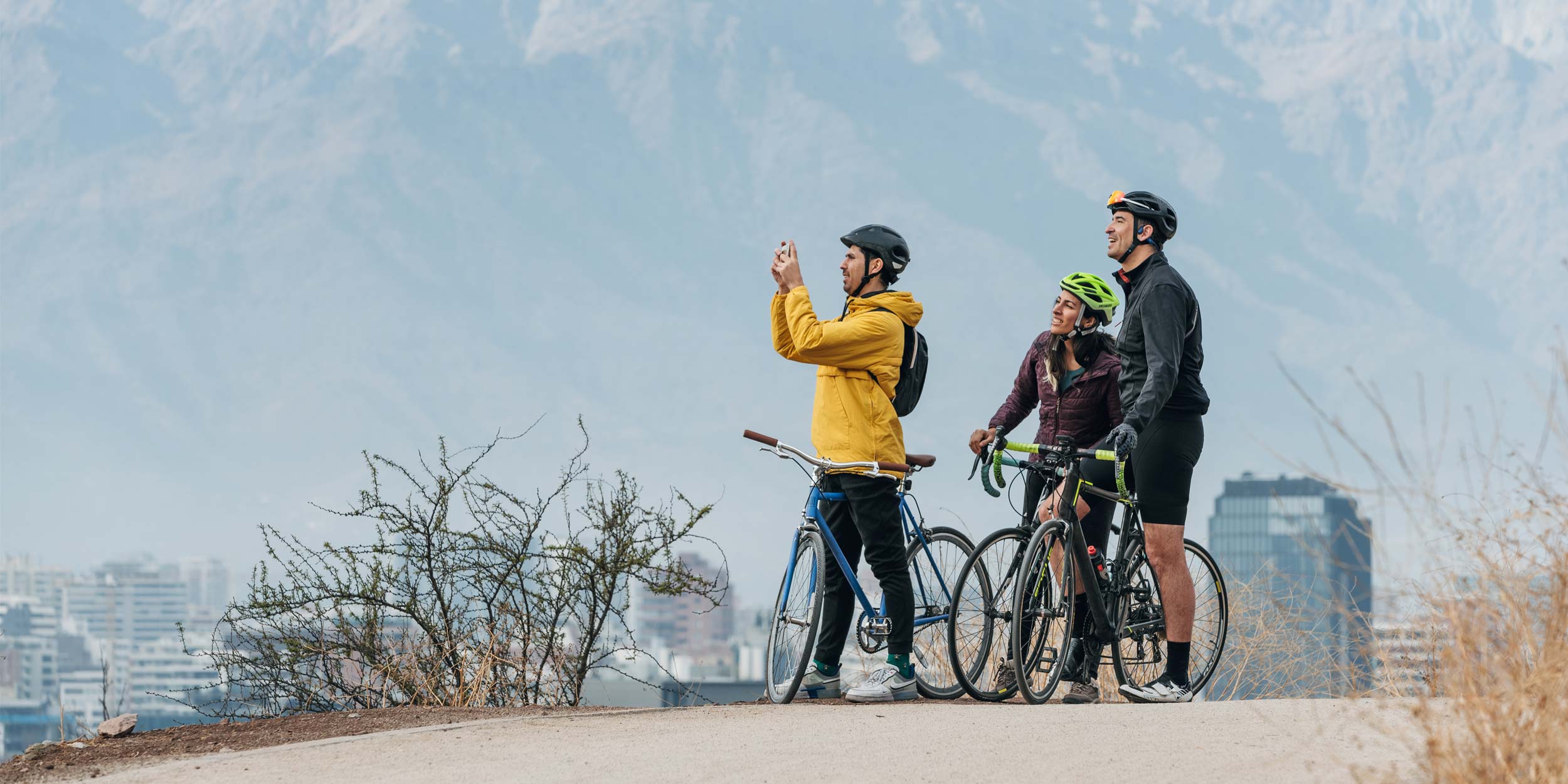 Group of cyclists taking a break and taking pictures of the view with smartphone