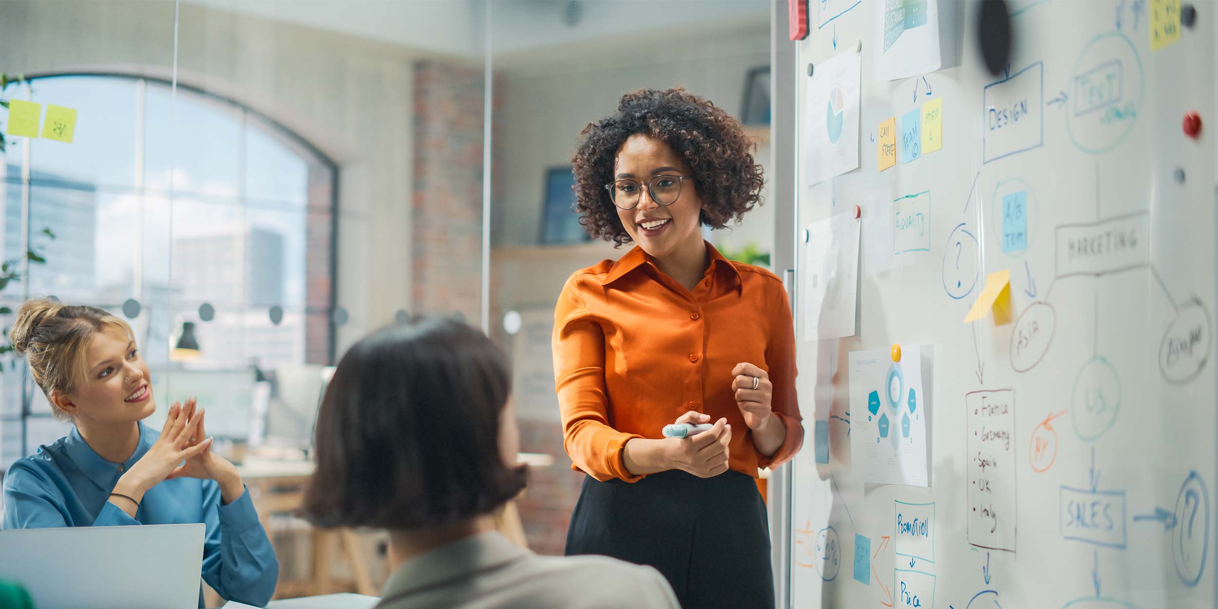 female director presents whiteboard with data