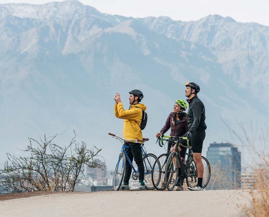 Group of cyclists taking a break and taking pictures of the view with smartphone