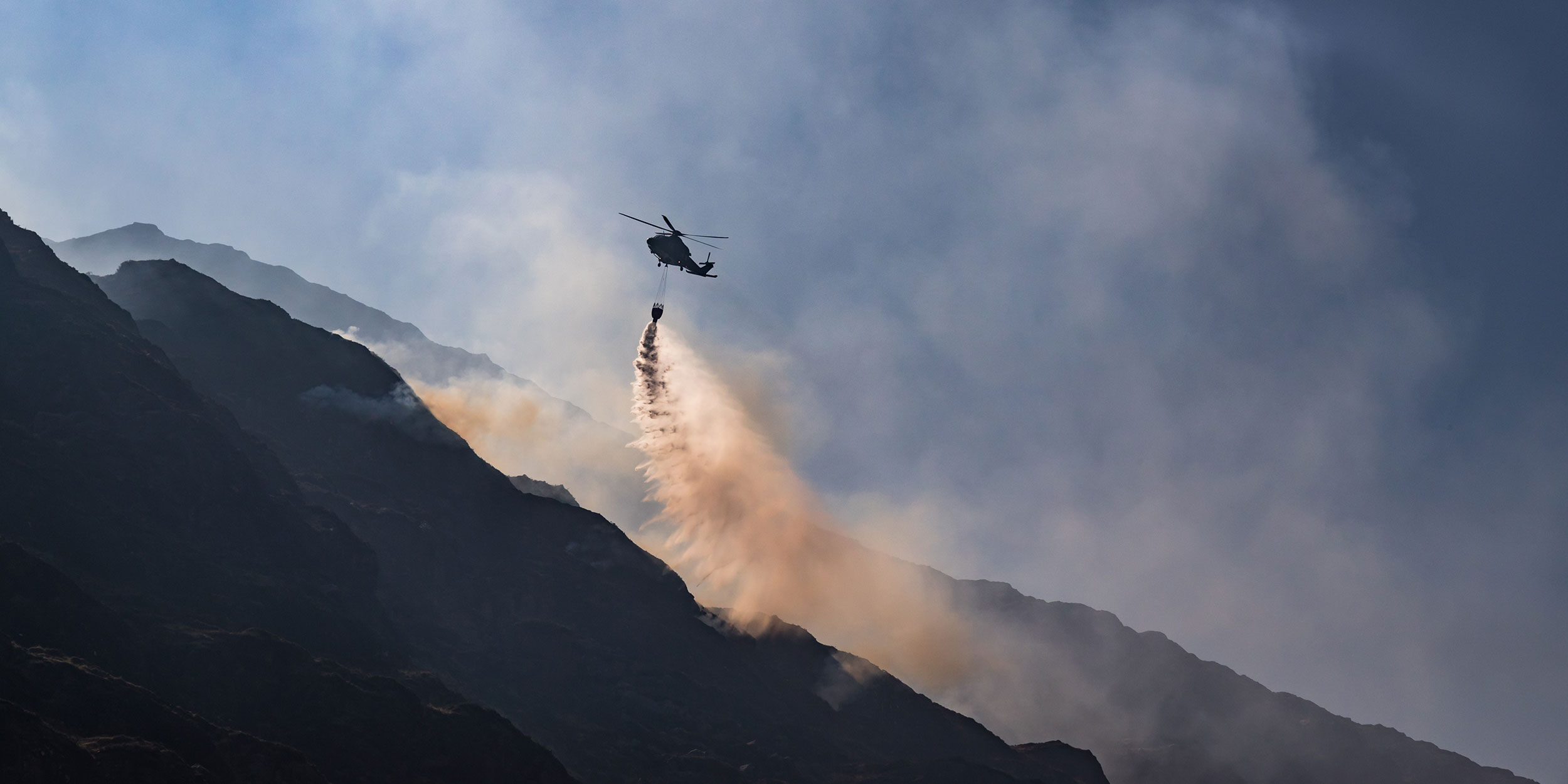 Helicopter dumps water to extinguish fire