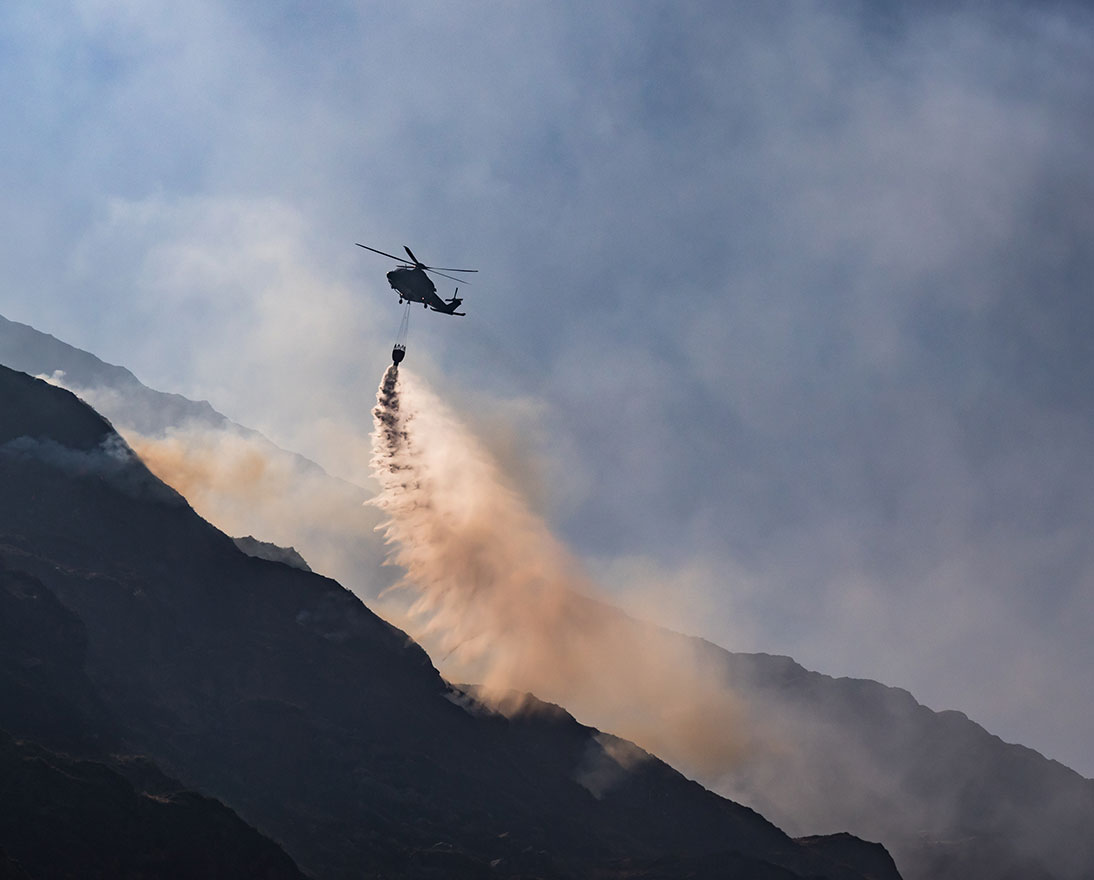 Helicopter dumps water to extinguish fire