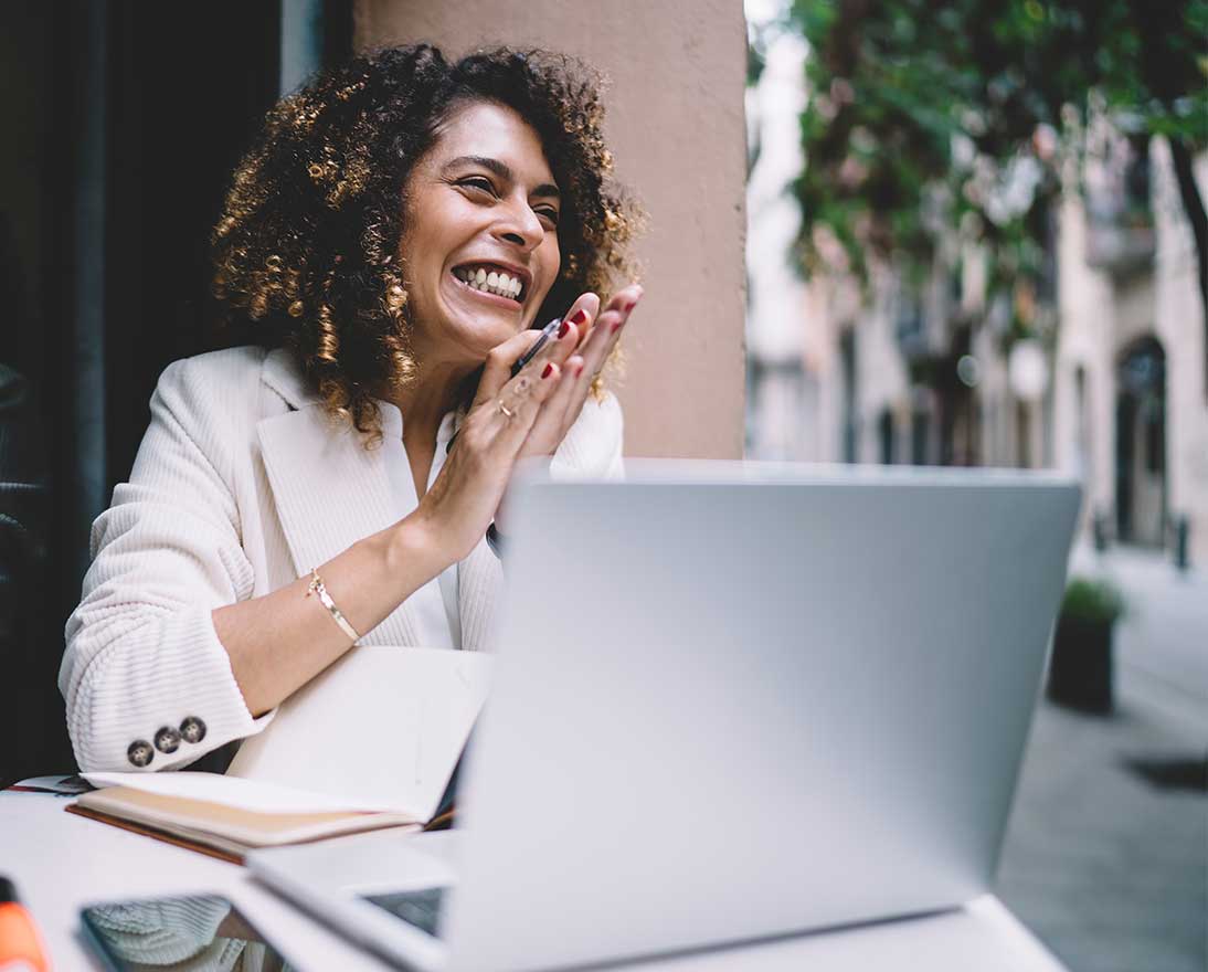 Cheerful woman works remotely on laptop