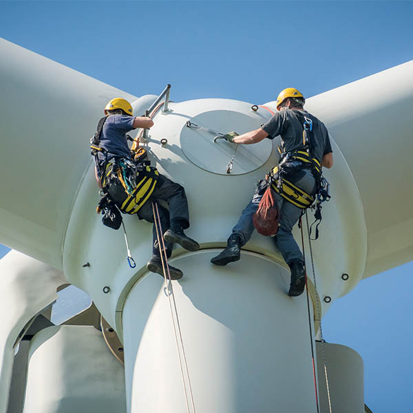 two workers working on a wind mill 