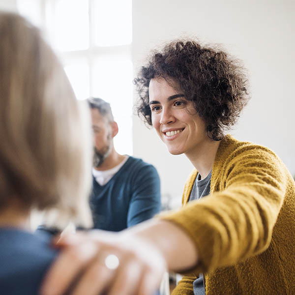 woman is putting her hand supportive on other woman's shoulder