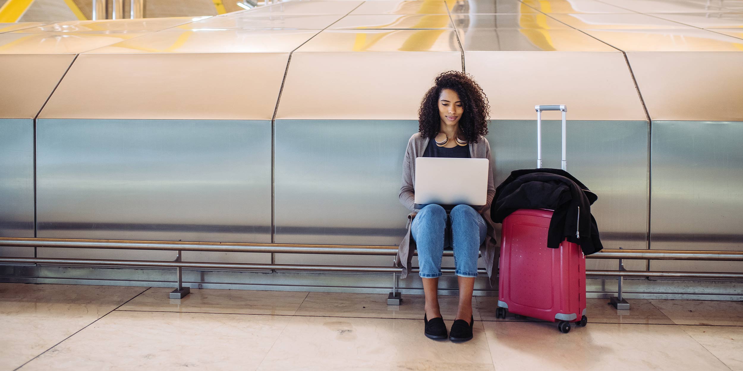 Woman working on her laptop at the airport