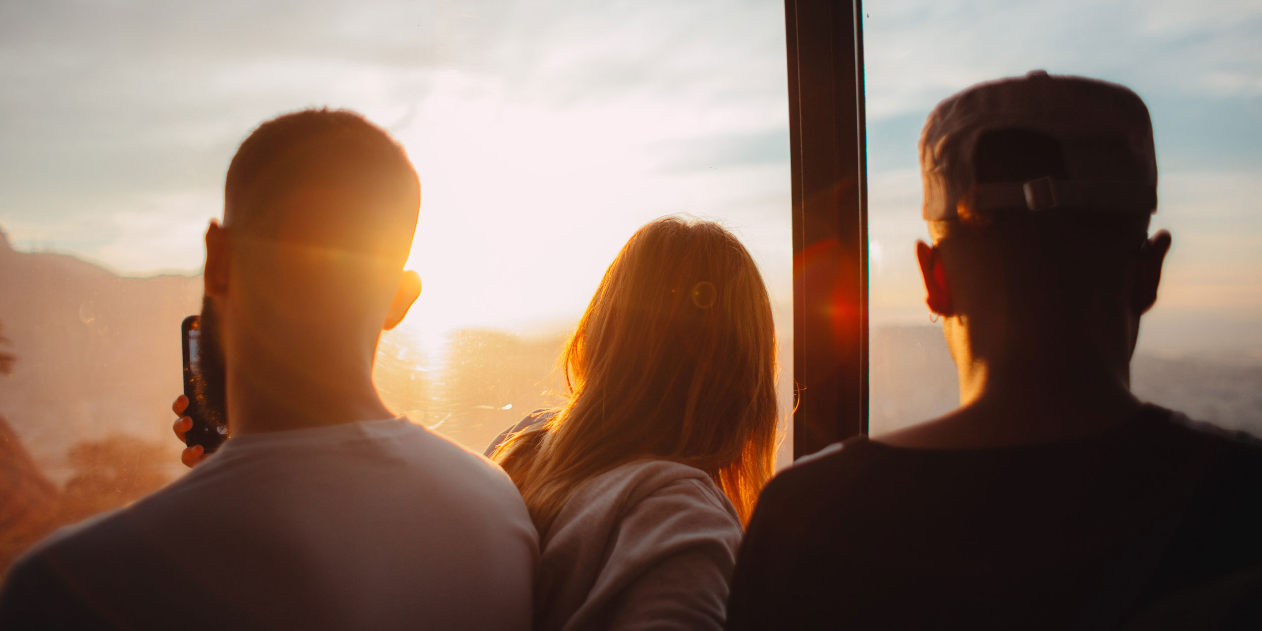 three people looking at a sunset 