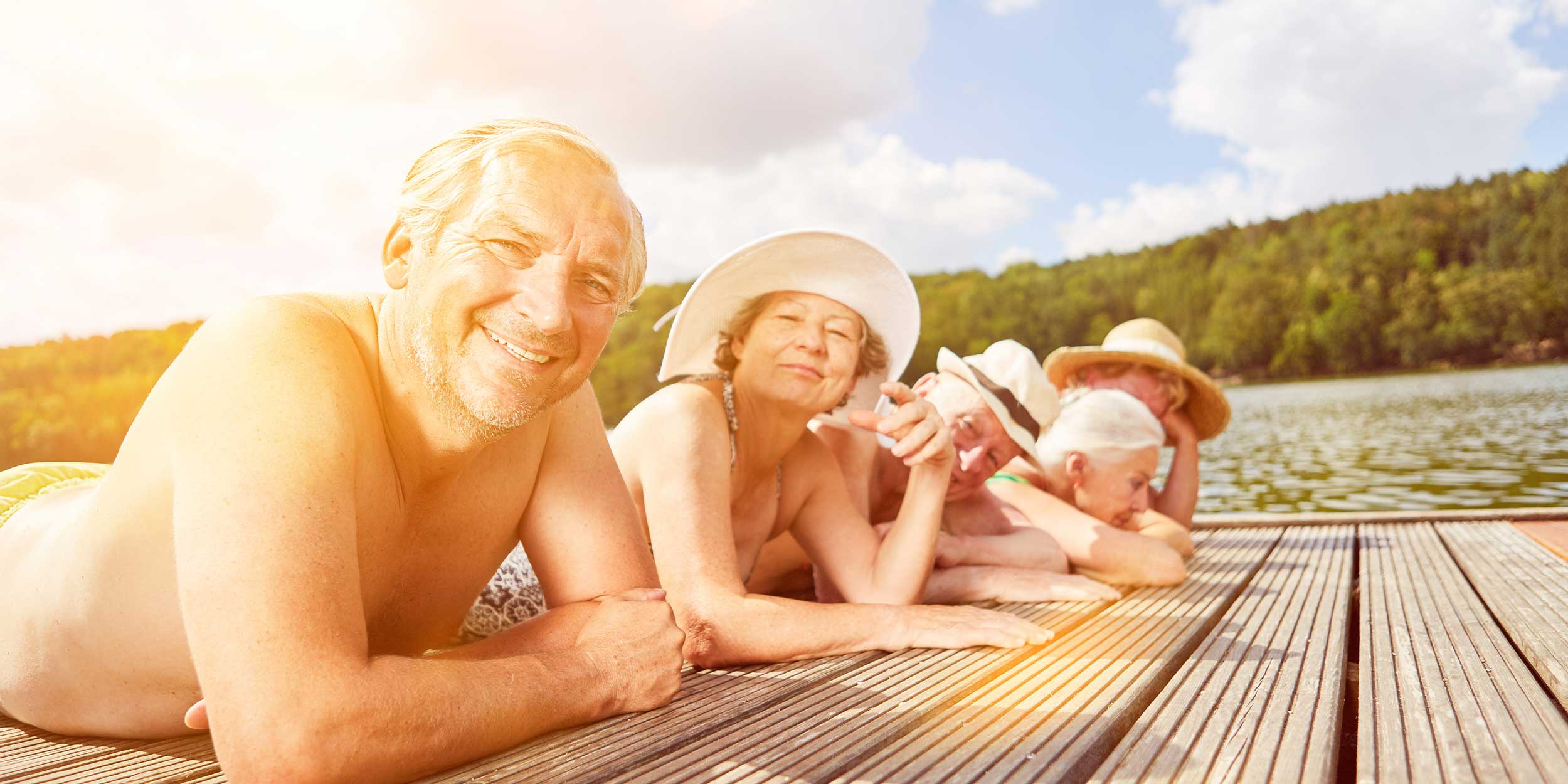 group of people laying in the sun by the water