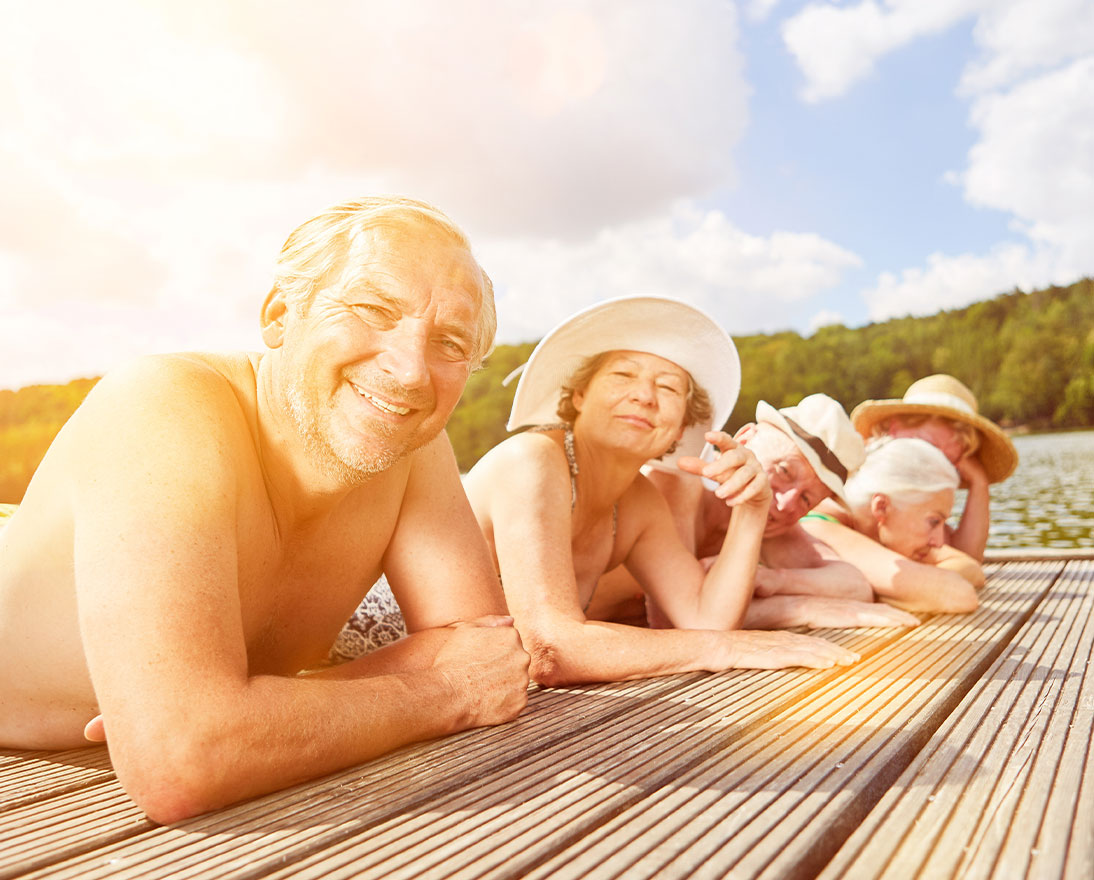 group of people laying in the sun by the water
