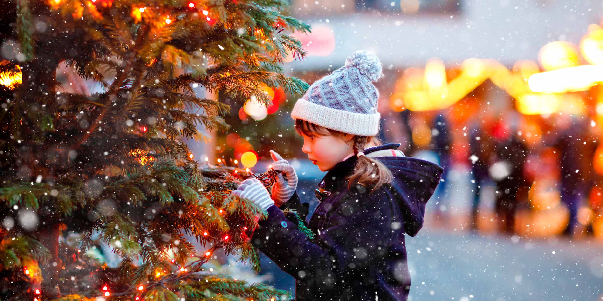 A girl touches a Christmas tree