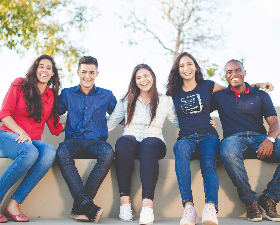 Group of GenZ people sitting together smiling