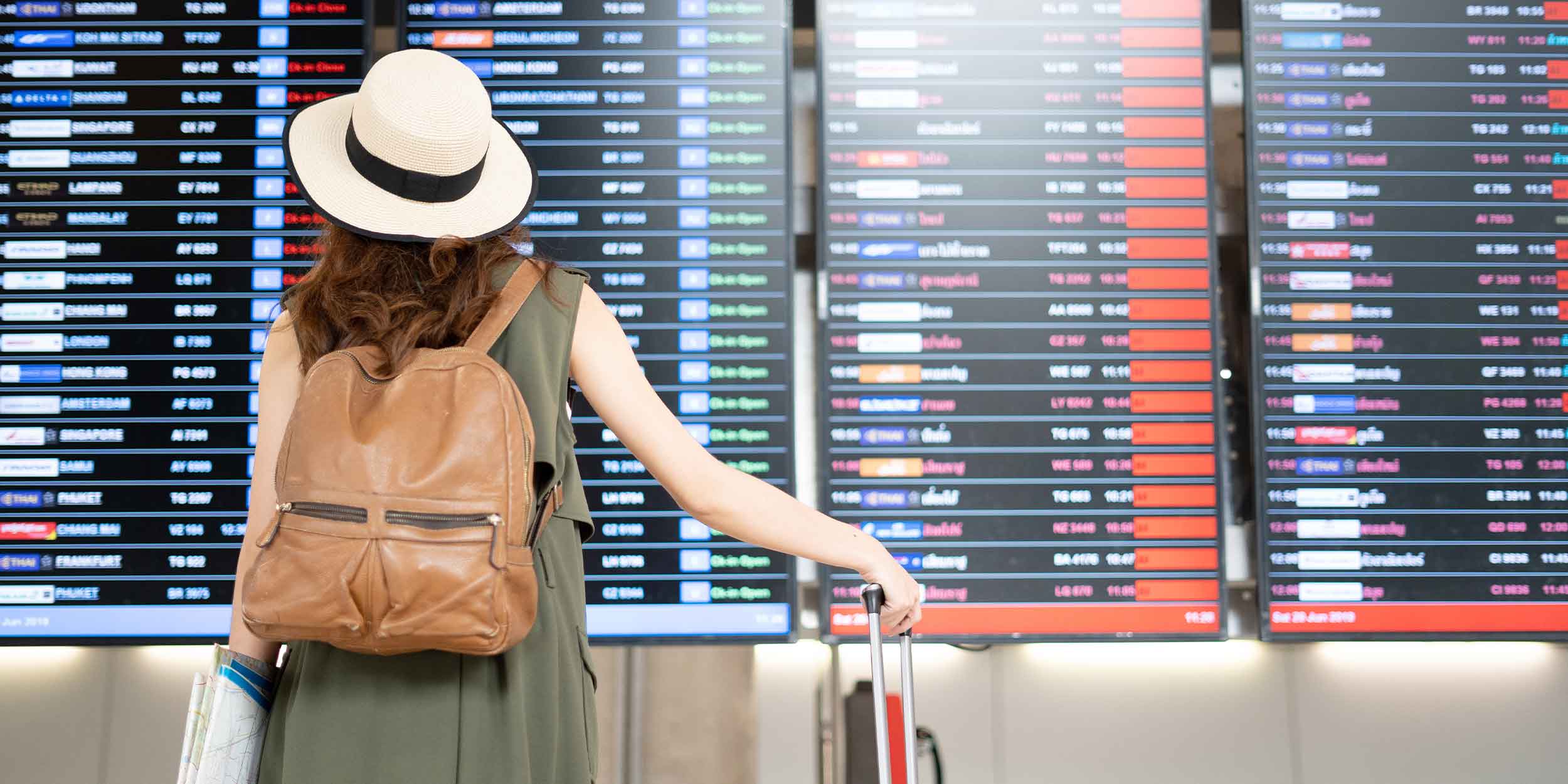 Woman looking at departures screen at the airport 
