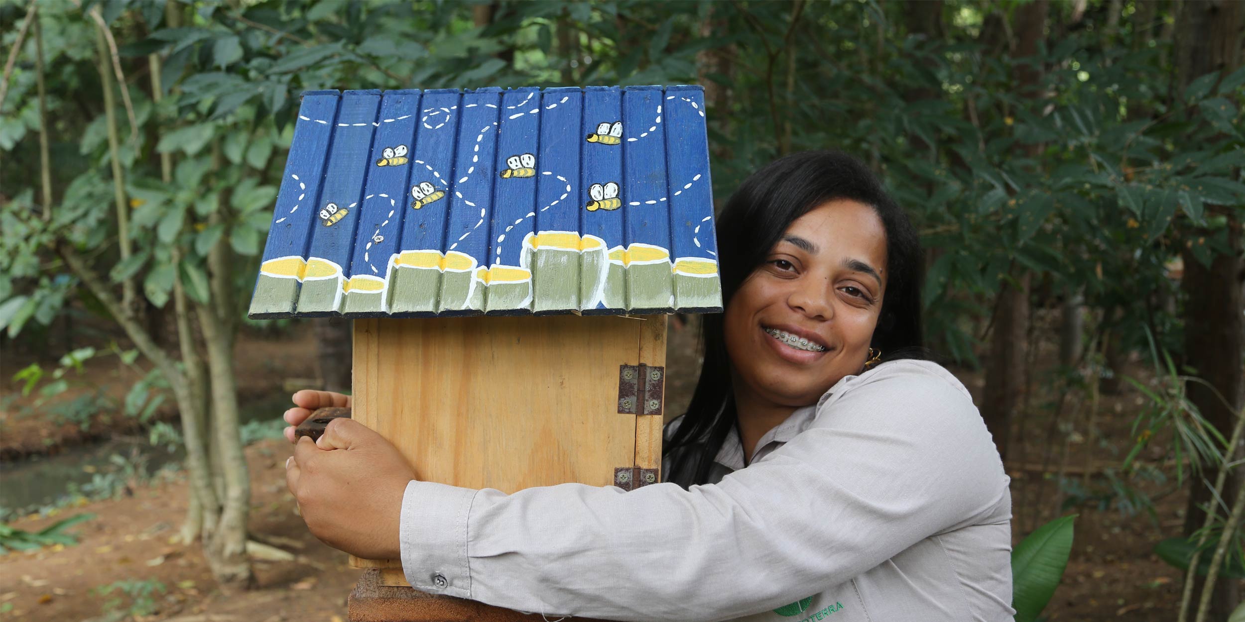 Kayla Maria Alves Fagiole, from Instituto Terra, hugging a stingless bee hive
