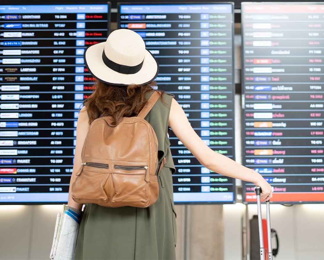 Woman looking at departures screen at the airport 