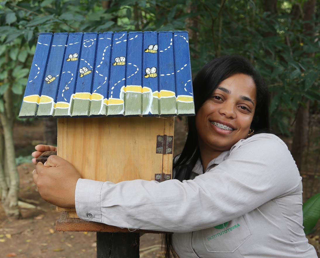 Kayla Maria Alves Fagiole, from Instituto Terra, hugging a stingless bee hive