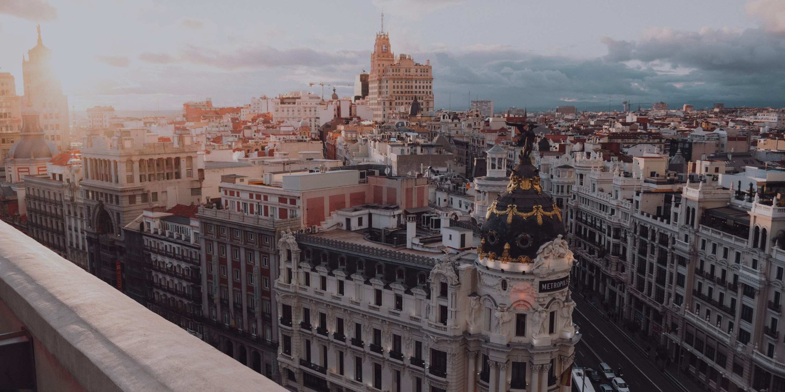 Aerial view of Madrid’s Gran Vía at sunset, featuring the iconic Metropolis building.