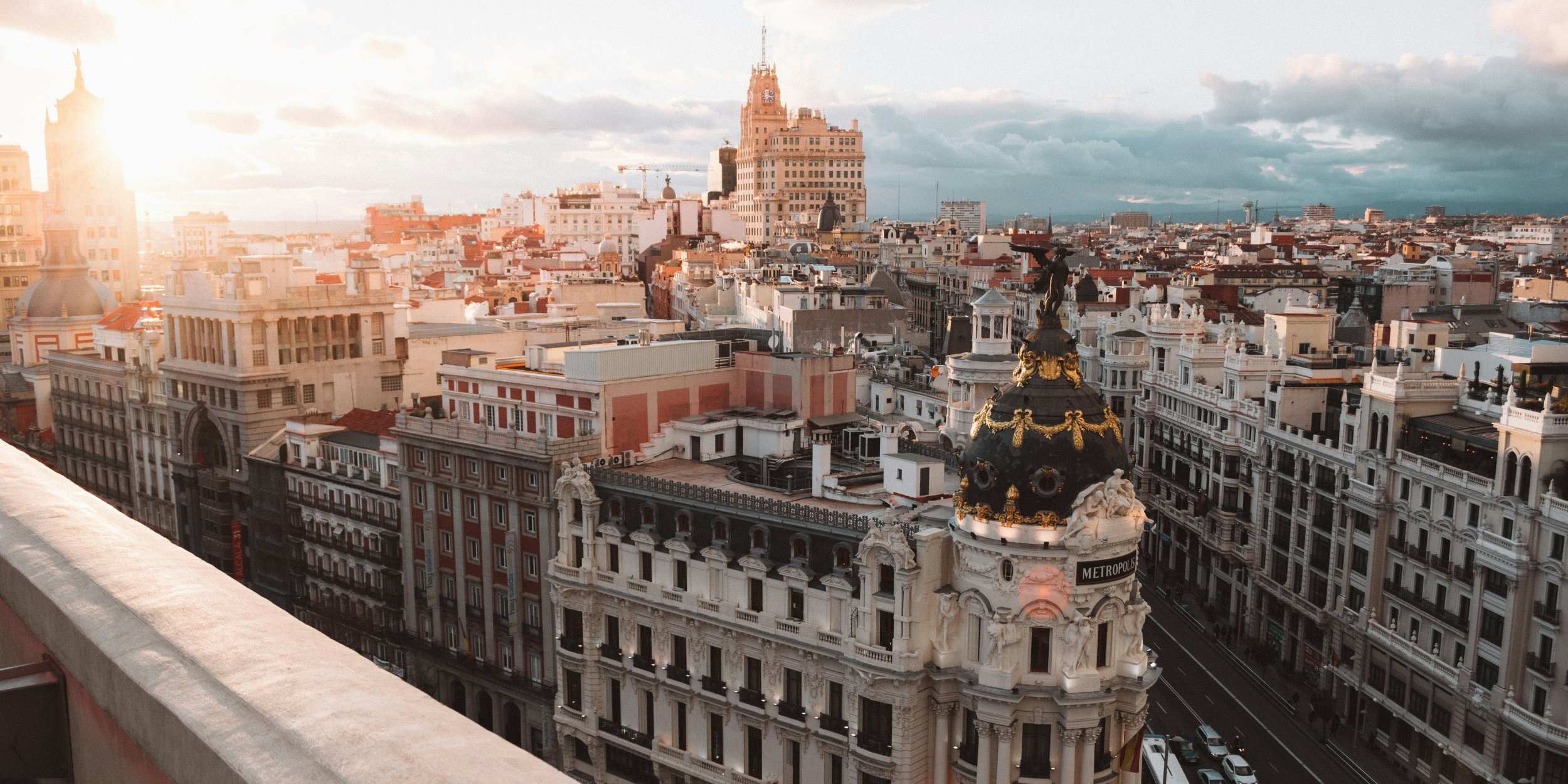 Aerial view of Madrid’s Gran Vía at sunset, featuring the iconic Metropolis building.