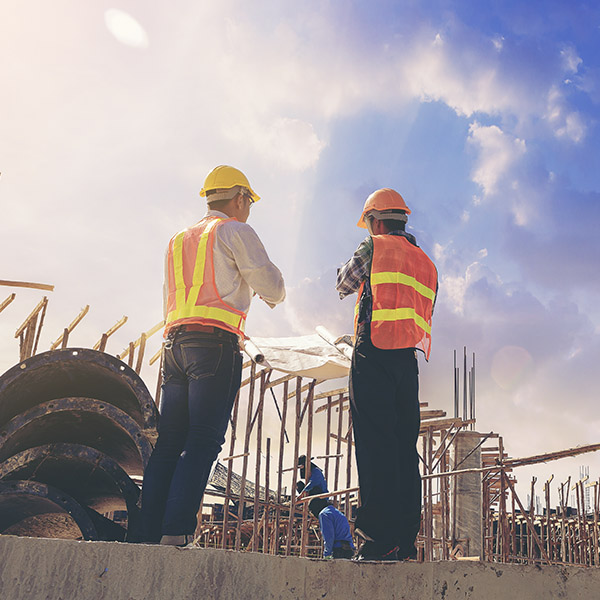 architect and foreman worker with blueprints discuss
