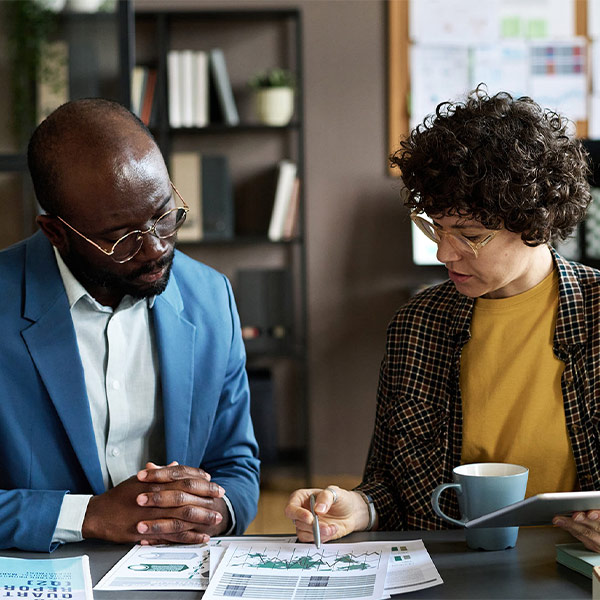two business people talking about graphs