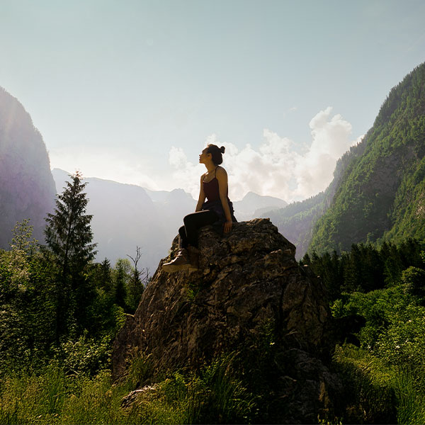 woman sitting on a rock in the mountains