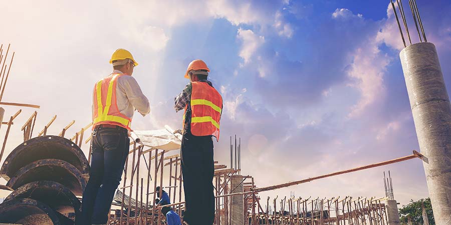 architect and foreman worker with blueprints discuss