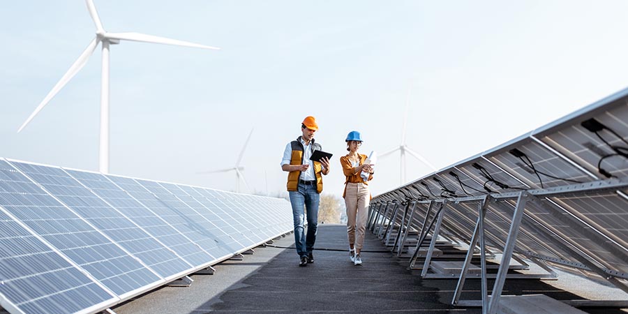 View on the rooftop solar power plant with two engineers walking